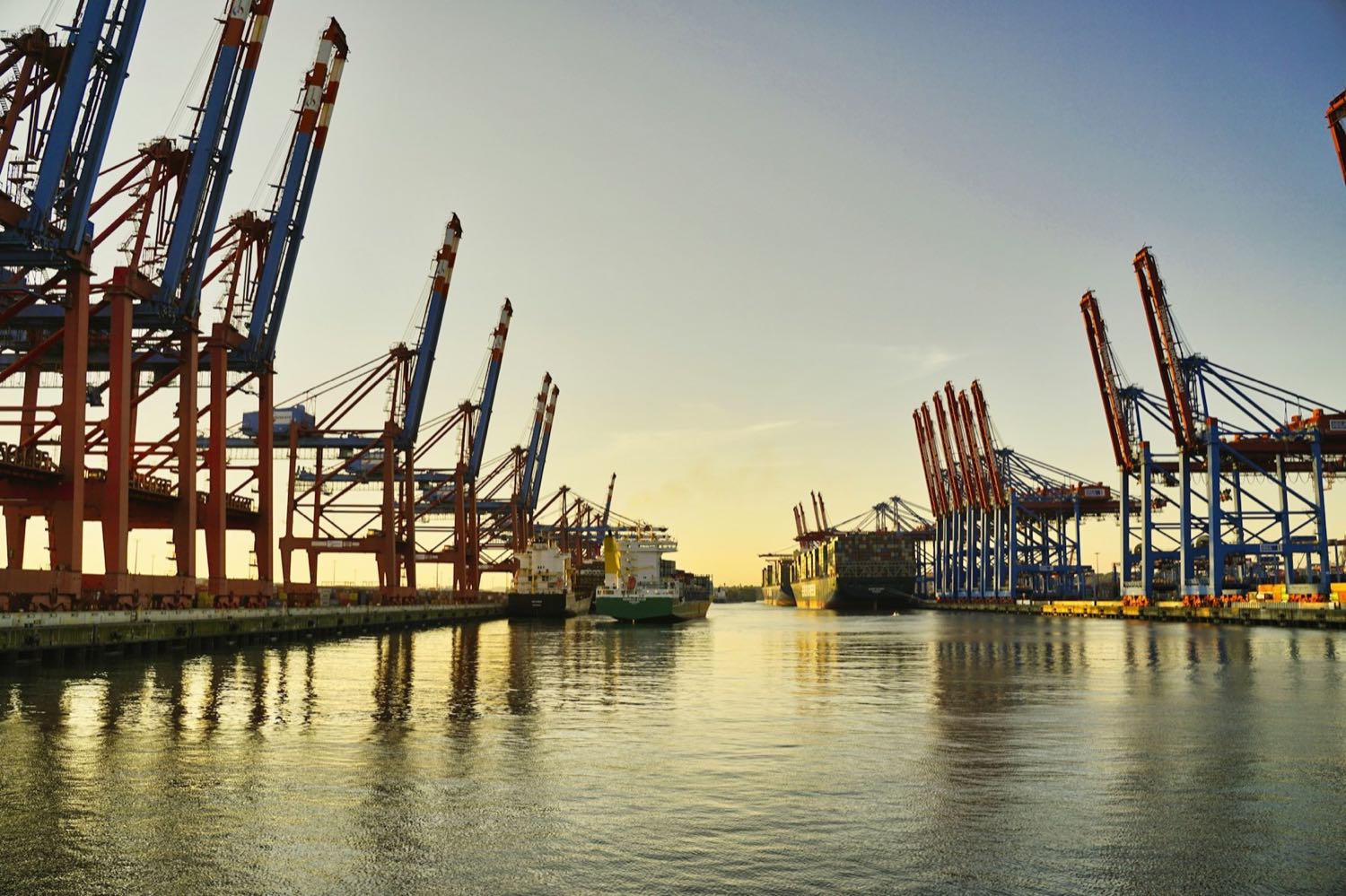 Container terminal at dawn, cranes and vessels along the quay