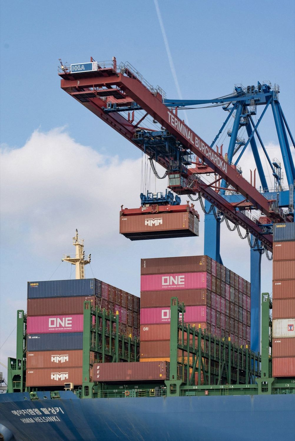 A ship-to-shore crane loading a container at a terminal
