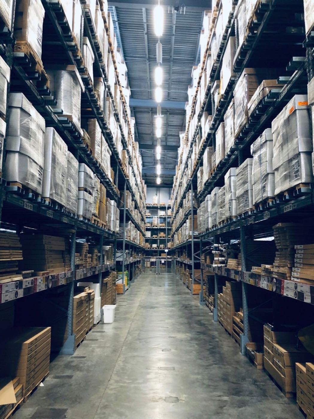 Warehouse aisle stacked with palletised cartons on racking